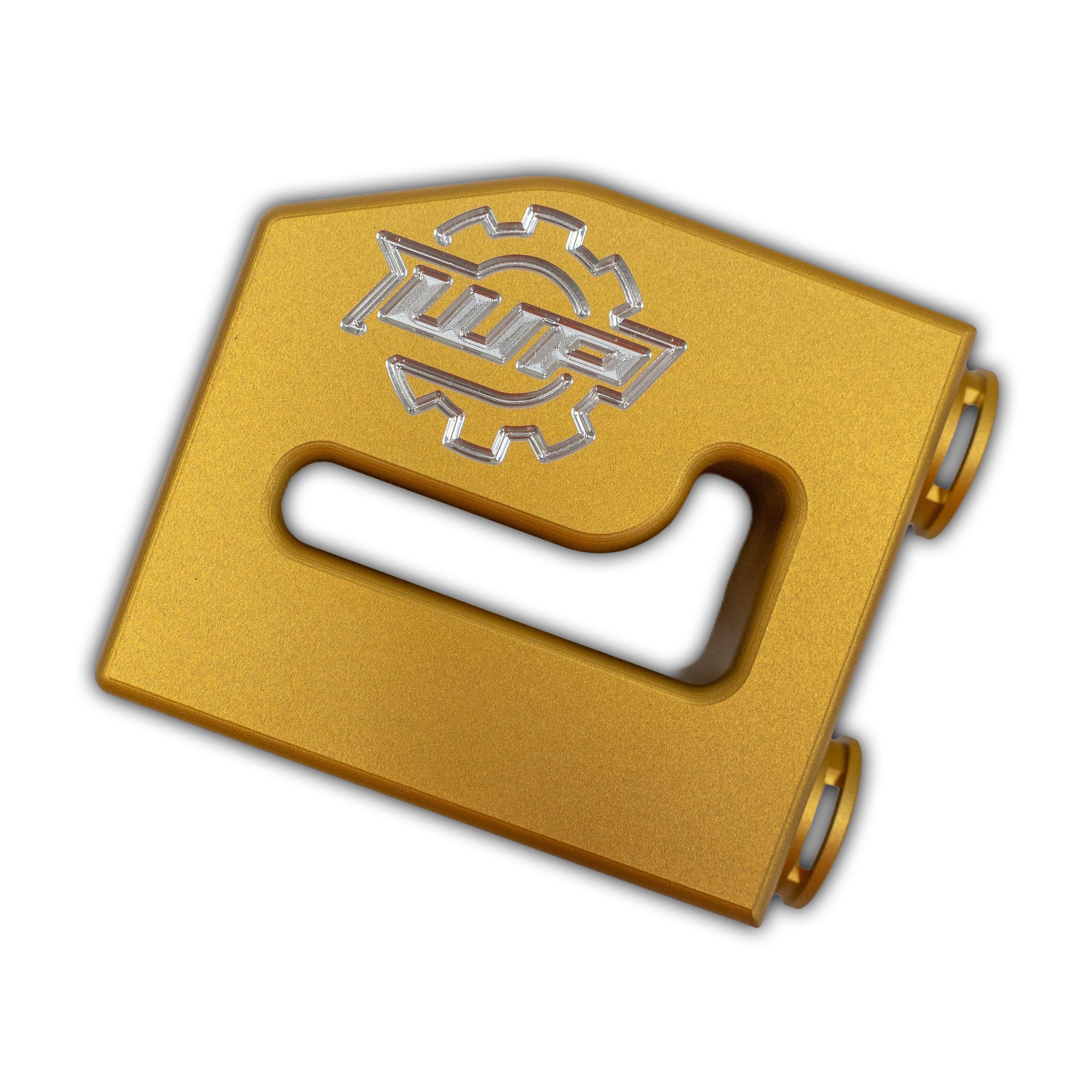 Close-up of a gold plastic handheld device with a silver embossed gear-like logo on its surface and a finger hole at the bottom corner.